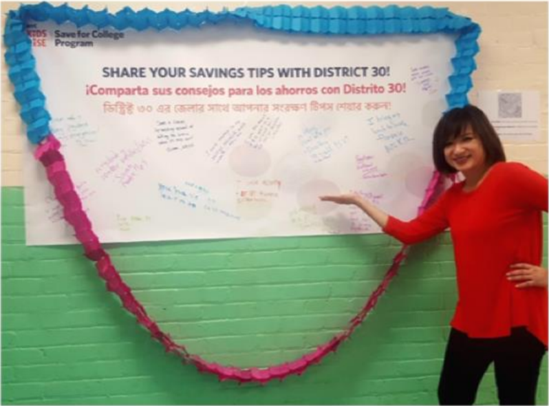 PS 69 first-grade teacher Ms. Gong at the Savings Tips Wall