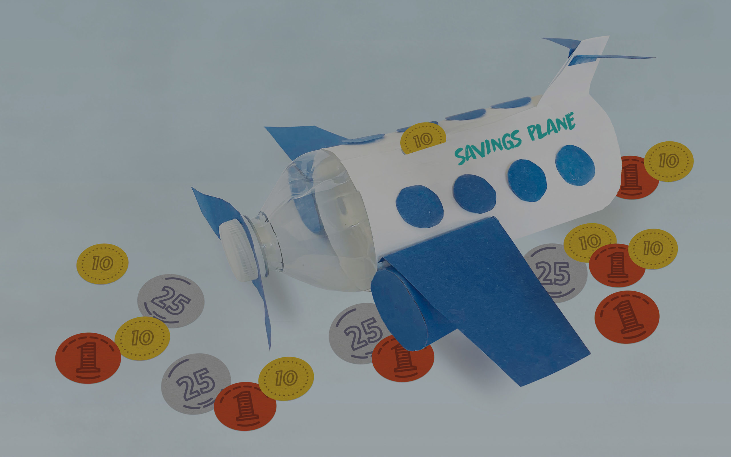 savings plane bank made from plastic bottle and construction paper with coins