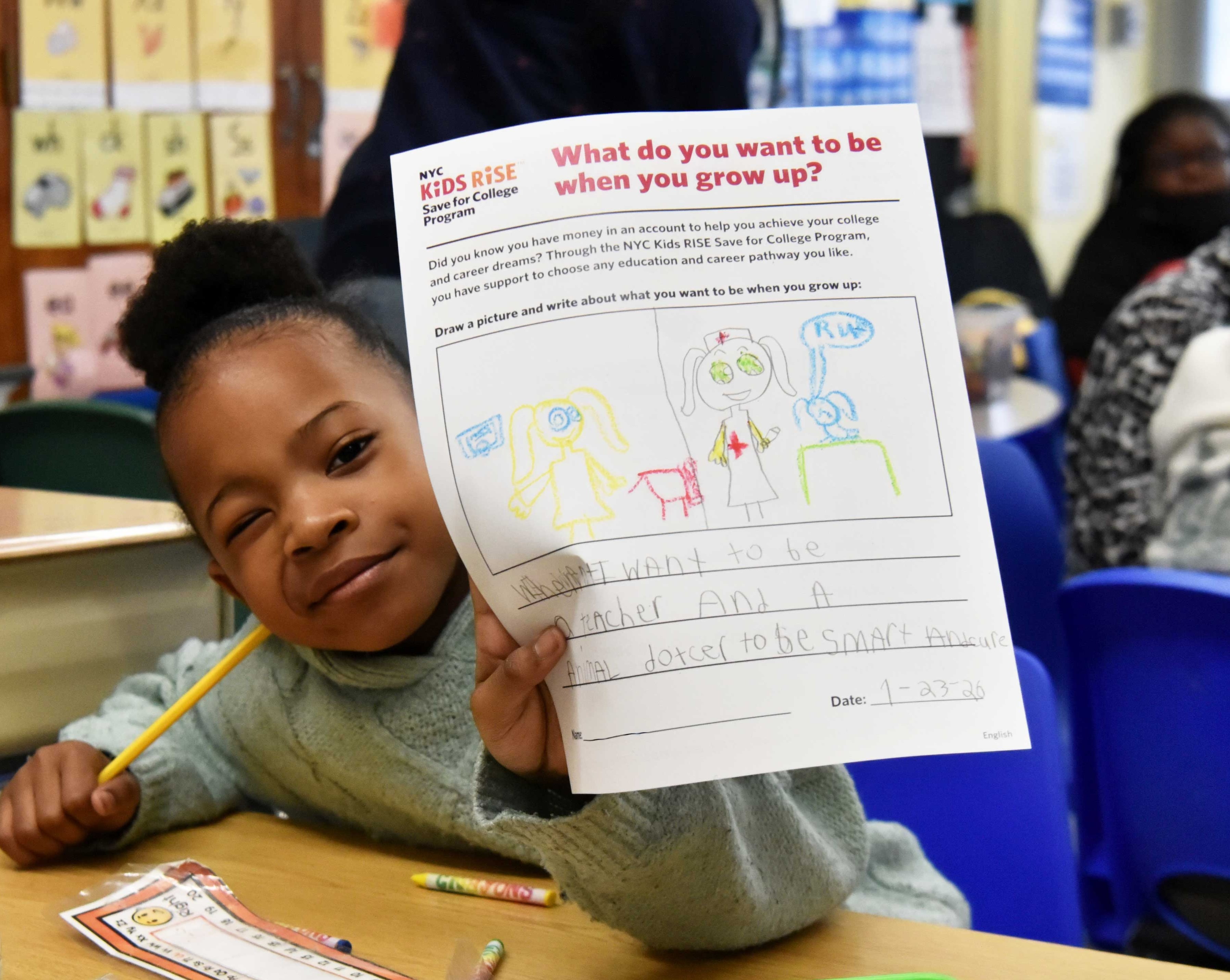 A P.S. 46 second grader draws and writes about what they want to be when they grow up and the school’s NYC Scholarship Month celebration. Photo by Bridget Ye for NYC Kids RISE (January 23, 2026). 