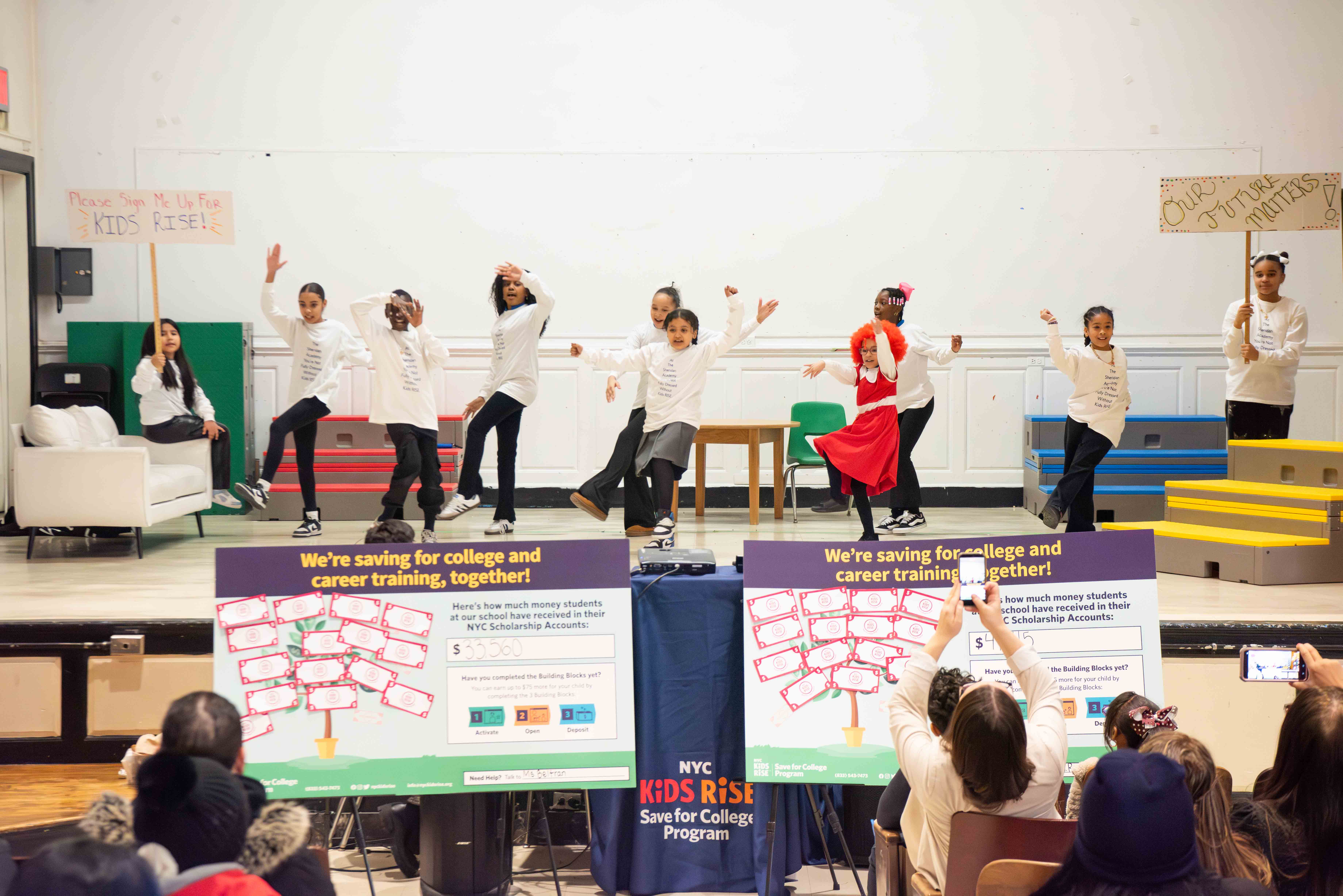 Students from Sheridan Academy for Young Leaders perform a rendition of “You’re Never Fully Dressed Without a Smile” from the musical Annie, retitled “You’re Never Fully Dressed Without Kids RISE” at the Campus 90 NYC Scholarship Month celebration Photo by Bridget Ye for NYC Kids RISE (January 29, 2026).